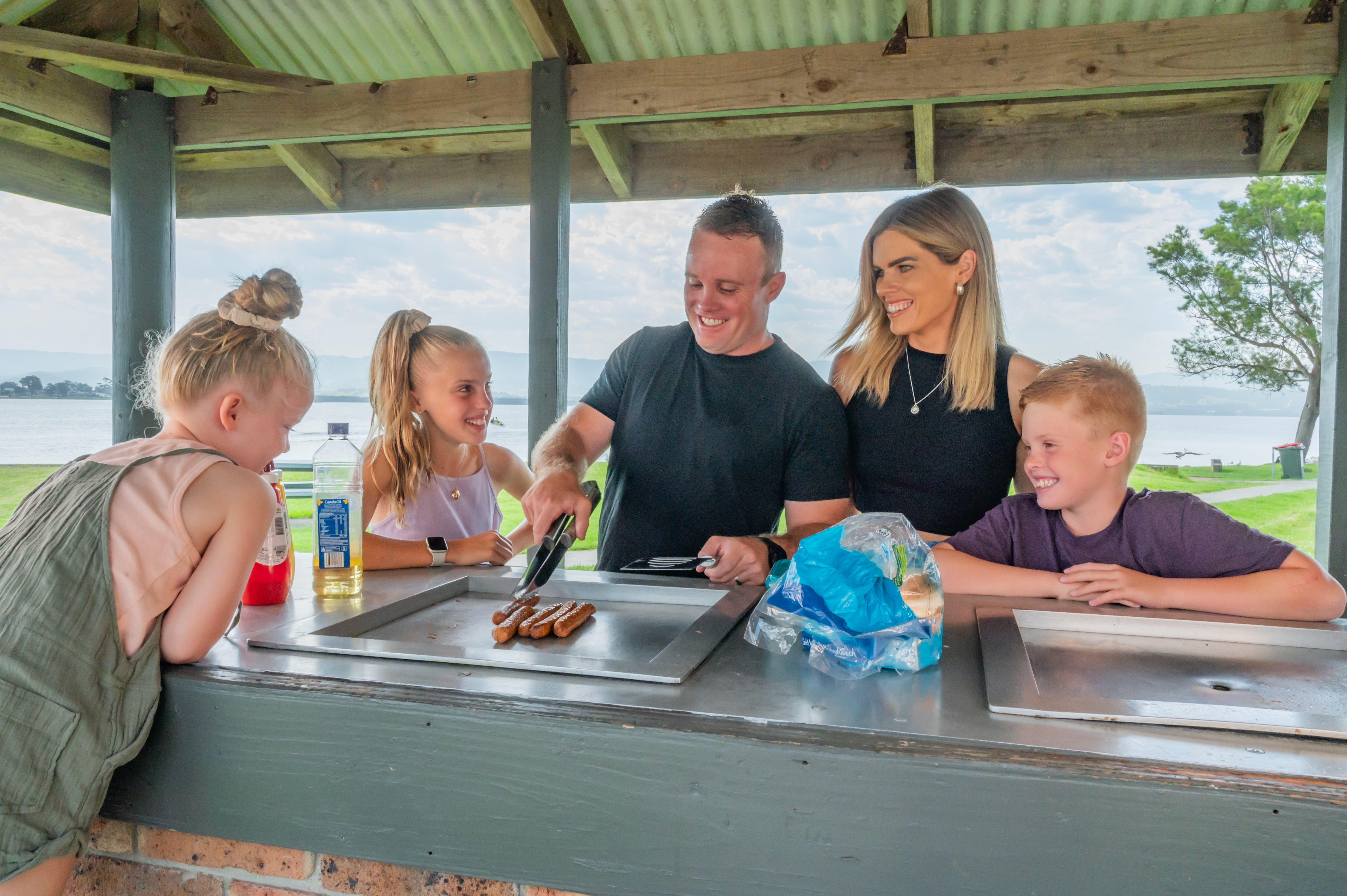 Family Cooking BBQ At Lake